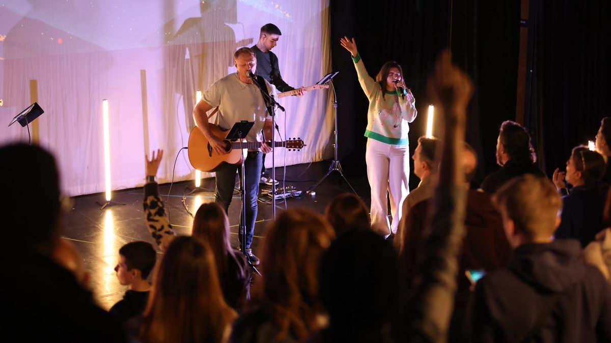 A worship gathering with hands raised