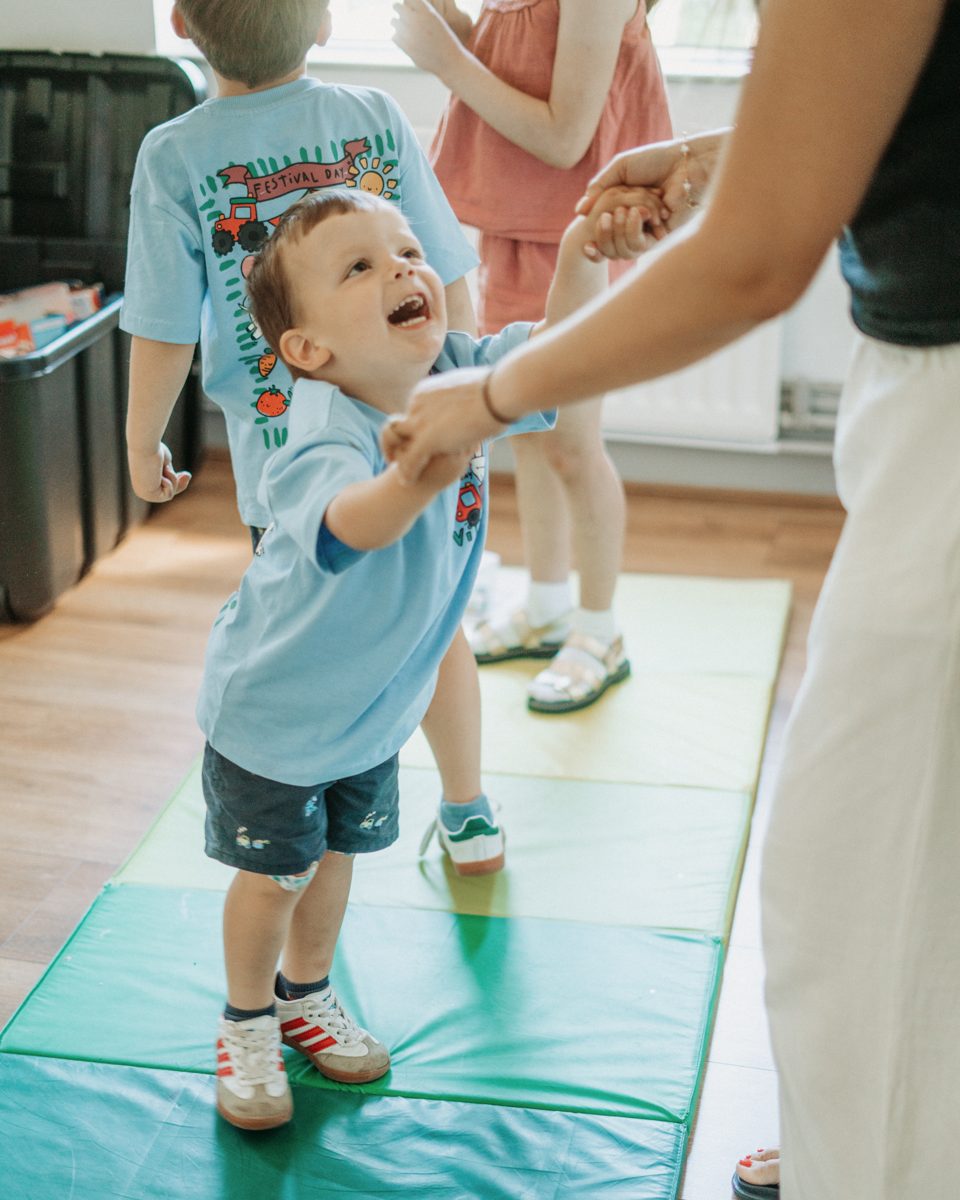 A toddler playing on a mat at Grow Kids